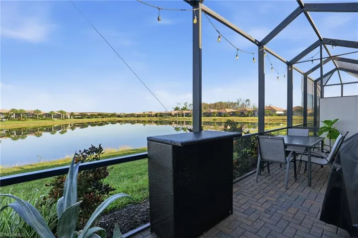 Sunroom with a water view, a residential view, and a patio area