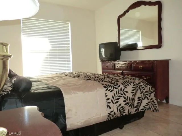 Room featuring tile flooring and a window with horizontal blinds