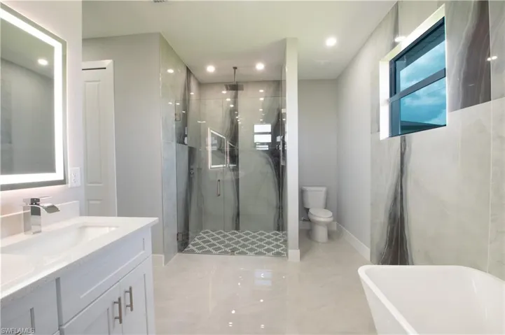 Full bathroom featuring independent shower and bath, toilet, and vanity