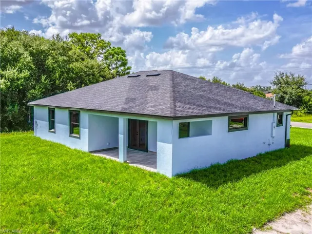 Back of house with a patio area and a yard