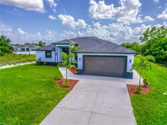 View of front of house with a garage and a front lawn