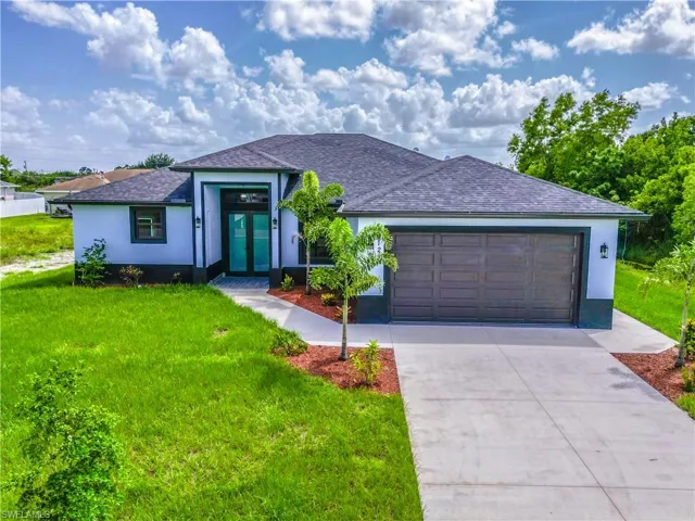 View of front of property featuring a garage and a front yard