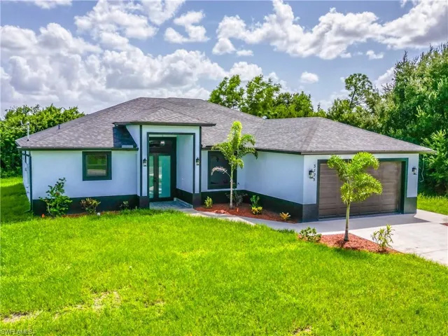 Ranch-style house featuring a front yard and a garage
