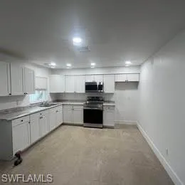 Kitchen featuring stainless steel appliances, white cabinets, light countertops, and recessed lighting