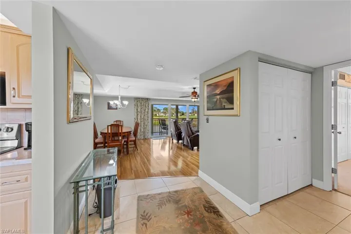 Hallway featuring light tile patterned flooring and an inviting chandelier