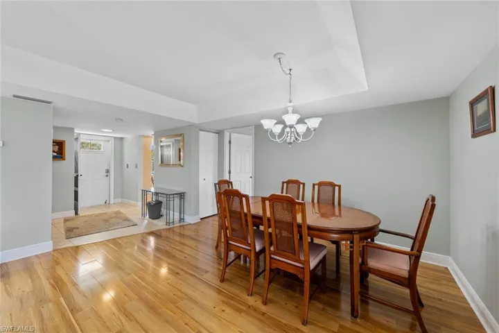 Dining space with light hardwood / wood-style flooring and a chandelier