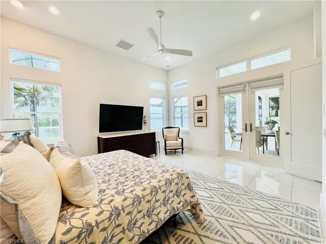 Bedroom with french doors, ceiling fan, multiple windows, and access to lanai