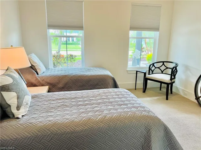 Guest bedroom featuring multiple windows, ceiling fan
