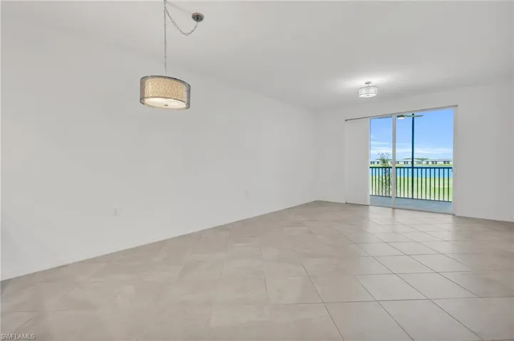 Unfurnished room with a water view and light tile patterned floors