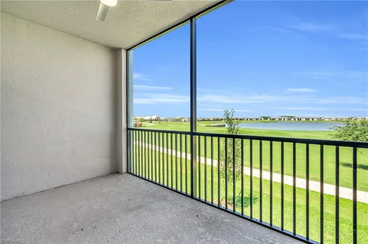 Unfurnished sunroom featuring ceiling fan and a water view