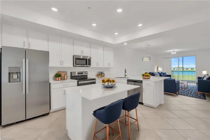 Kitchen with a center island, white cabinetry, a kitchen breakfast bar, a water view, and appliances with stainless steel finishes