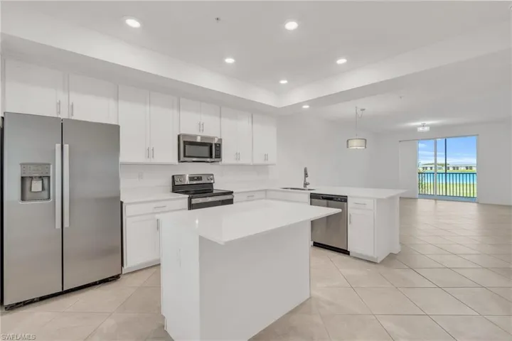 Kitchen with pendant lighting, sink, kitchen peninsula, a kitchen island, and stainless steel appliances
