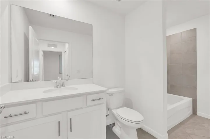 Bathroom featuring tile patterned flooring, vanity, and toilet