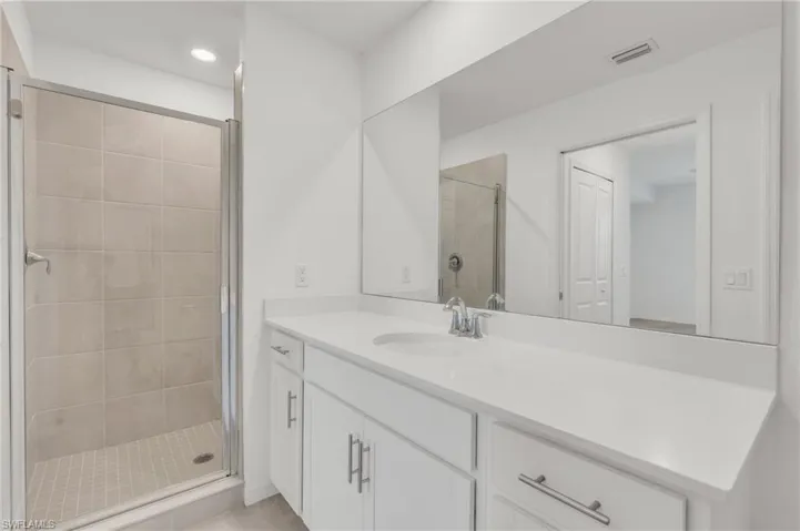 Bathroom with vanity and a shower with door