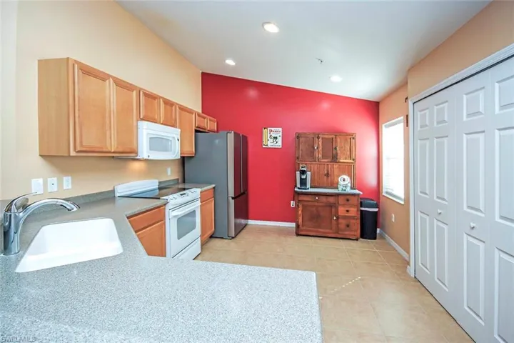Kitchen featuring white appliances, light countertops, and light tile patterned flooring