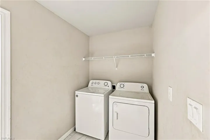 Laundry area with a clothes washer and dryer, finished with wire shelving and light-colored walls