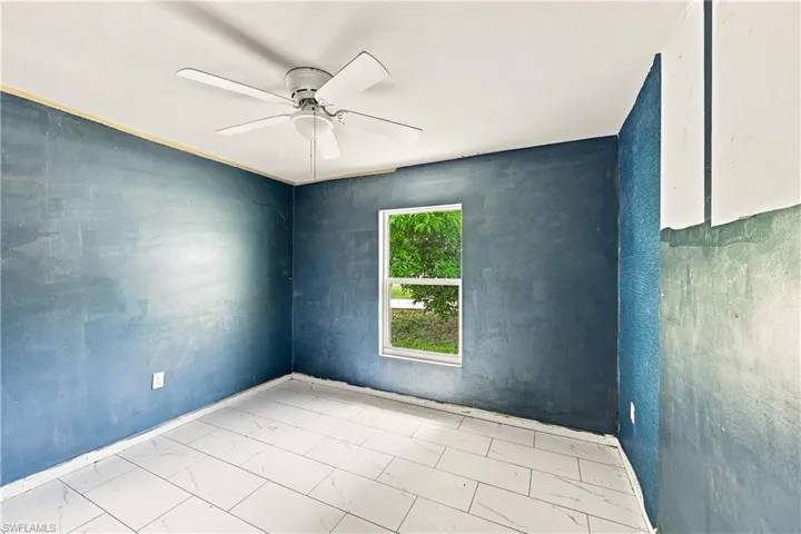 White ceiling fan, white tile flooring, single window, and painted walls