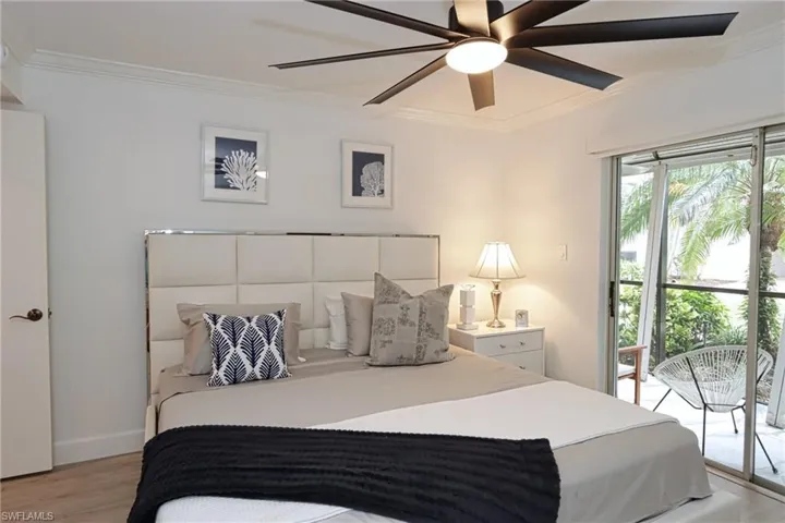 Bedroom with ornamental molding, light wood-style floors, a ceiling fan, baseboards, and access to outside
