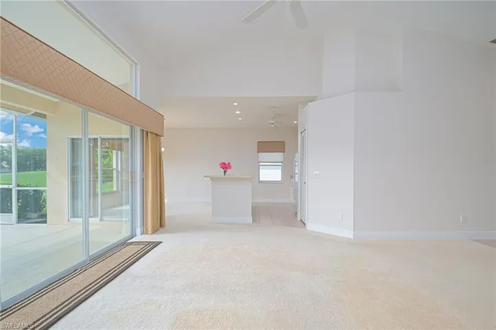Spacious living room opens to lanai, kitchen, and dining room. Shown without furniture.