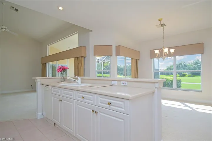 Kitchen with bright sunshine all day, light carpet, neutral countertops, white cabinets and appliances, amazing views!