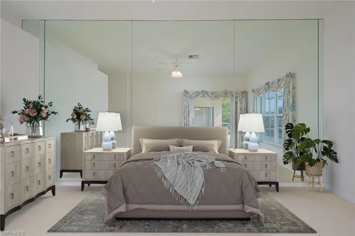 Staged Photo Primary Bedroom featuring light carpet and designer mirror and ceiling fan.