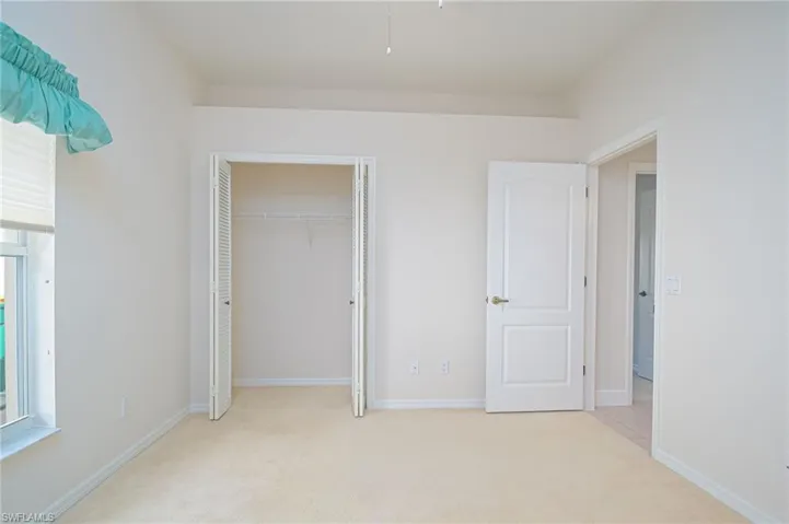 Unfurnished SECOND bedroom featuring a closet and light carpet