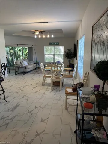 Dining room featuring light marble flooring, plenty of natural light, and a ceiling fan