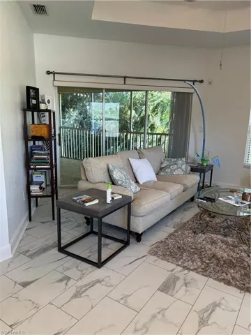 Living room featuring baseboards and light marble finish floors