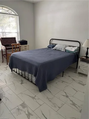 Bedroom featuring light marble finish floors
