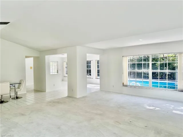 Unfurnished room with light colored carpet and plenty of natural light
