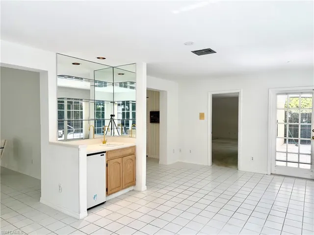 Bar area featuring light countertops, white dishwasher, light brown cabinetry, and healthy amount of natural light