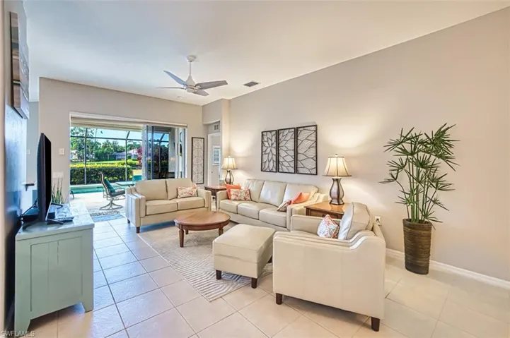 Living area with a ceiling fan and light tile patterned flooring