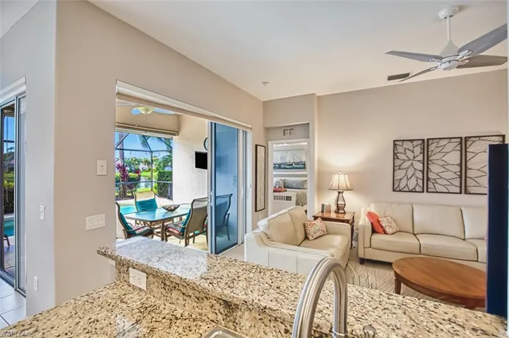 Living room featuring a ceiling fan, a sunroom, and light tile patterned floors