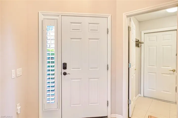 Foyer entrance featuring light tile patterned floors and baseboards