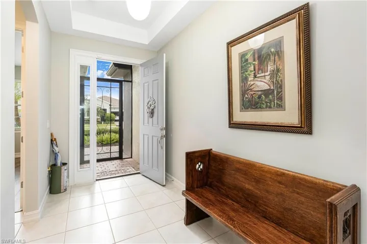 Entrance foyer with light tile patterned flooring and a raised ceiling