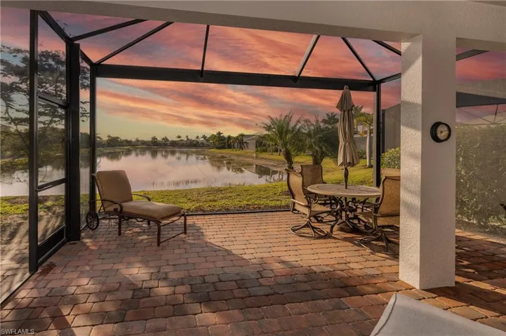 Patio terrace at dusk with a water view, a lanai, a patio area, and outdoor dining area