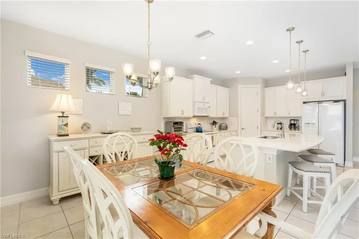 Dining area with light tile patterned floors, a chandelier, and recessed lighting