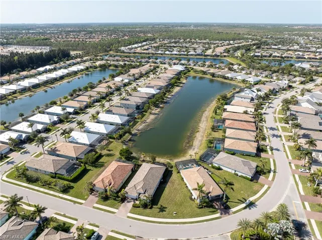 Aerial view of property and surrounding area featuring nearby suburban area and a nearby body of water