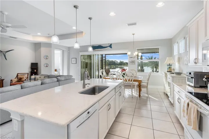 Kitchen with white appliances, light tile patterned floors, white cabinets, a ceiling fan, and recessed lighting