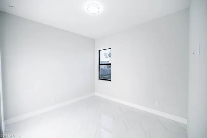 Empty room featuring baseboards and light marble finish flooring