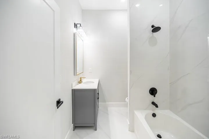 Bathroom featuring vanity and washtub / shower combination