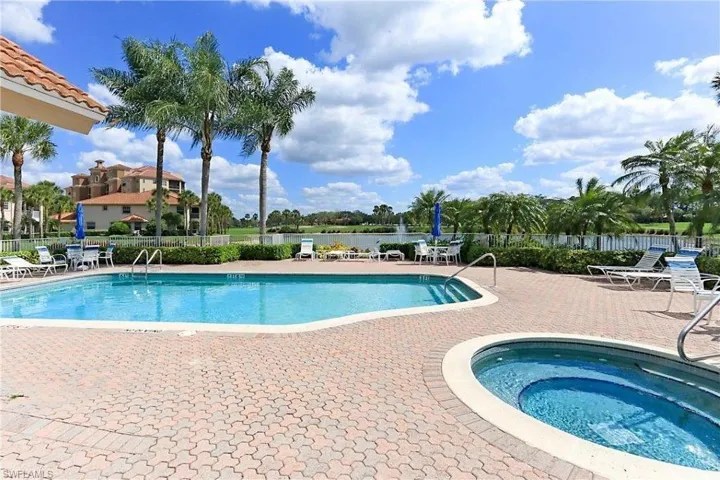 Community pool with a patio and a hot tub