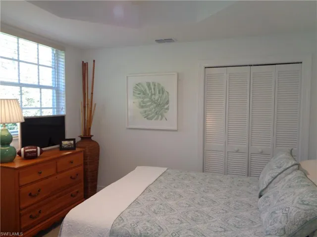 Bedroom featuring a closet, ceiling fan, and a raised ceiling