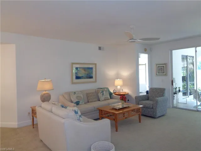 Living room featuring light colored carpet and ceiling fan