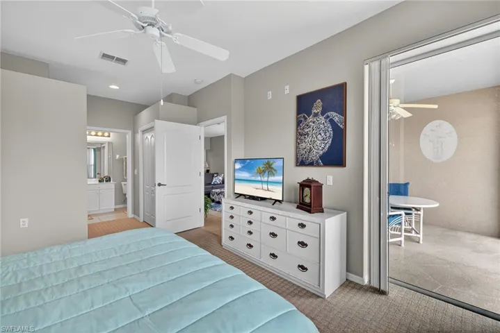 Bedroom featuring light carpet, connected bathroom, ceiling fan, and a closet