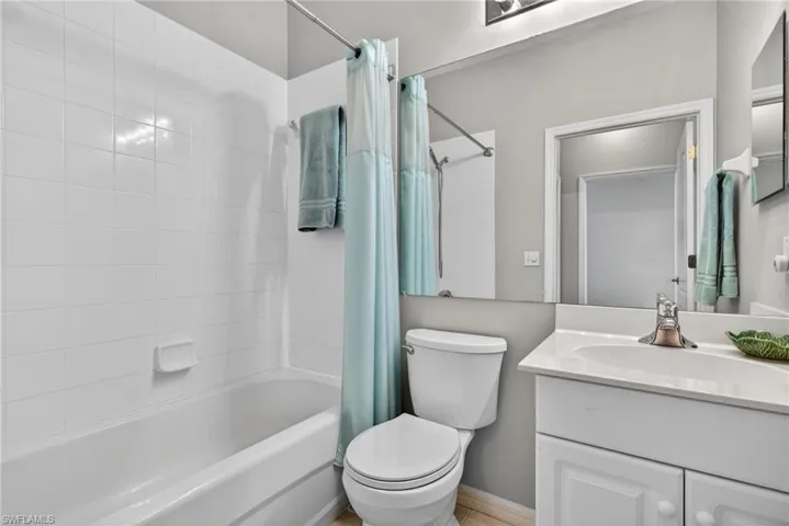 Full bath featuring shower / bath combo with shower curtain and vanity
