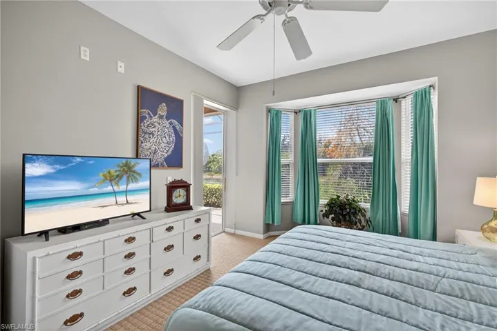 Bedroom featuring access to exterior, light colored carpet, and ceiling fan