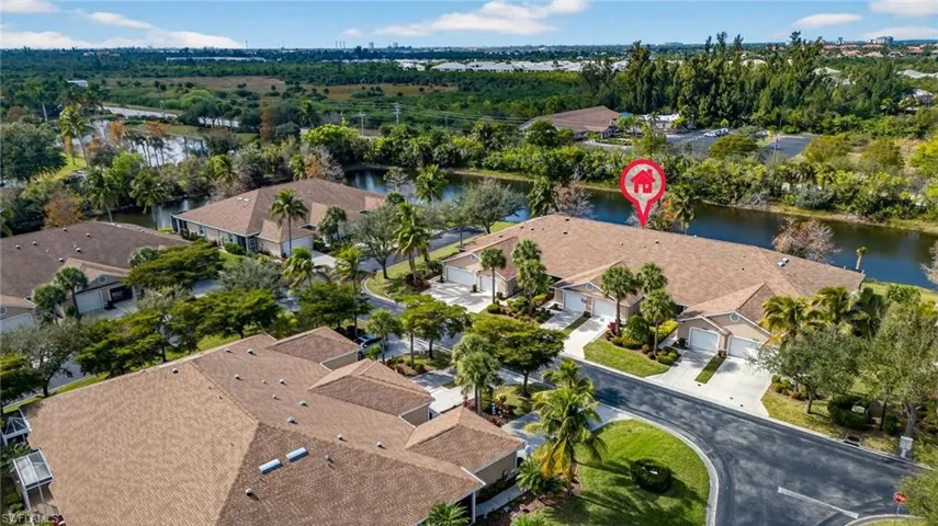 Aerial view of property's location featuring a nearby body of water and a tree filled landscape