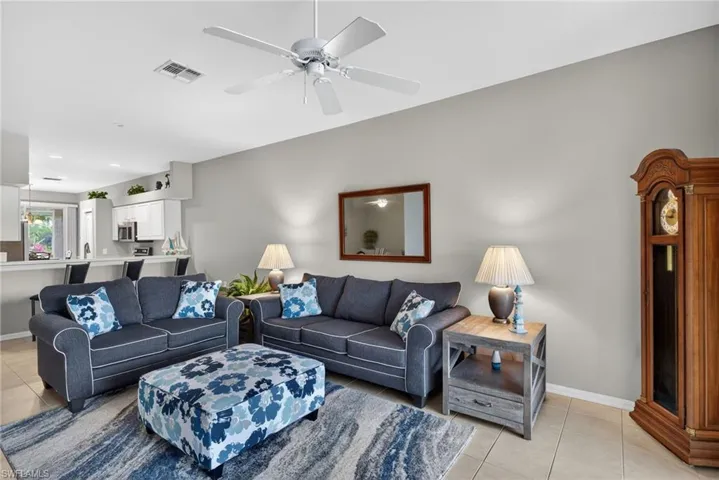Living area with light tile patterned floors, a ceiling fan, and recessed lighting