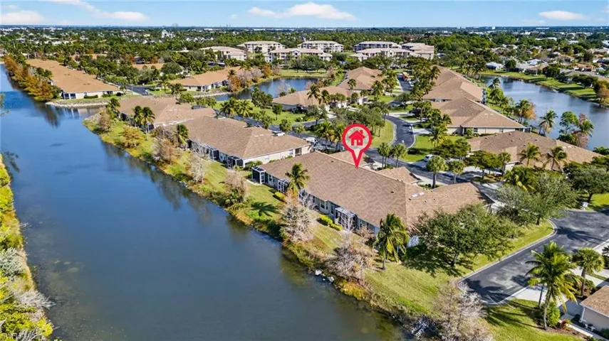 Aerial view of property's location featuring a nearby body of water and nearby suburban area